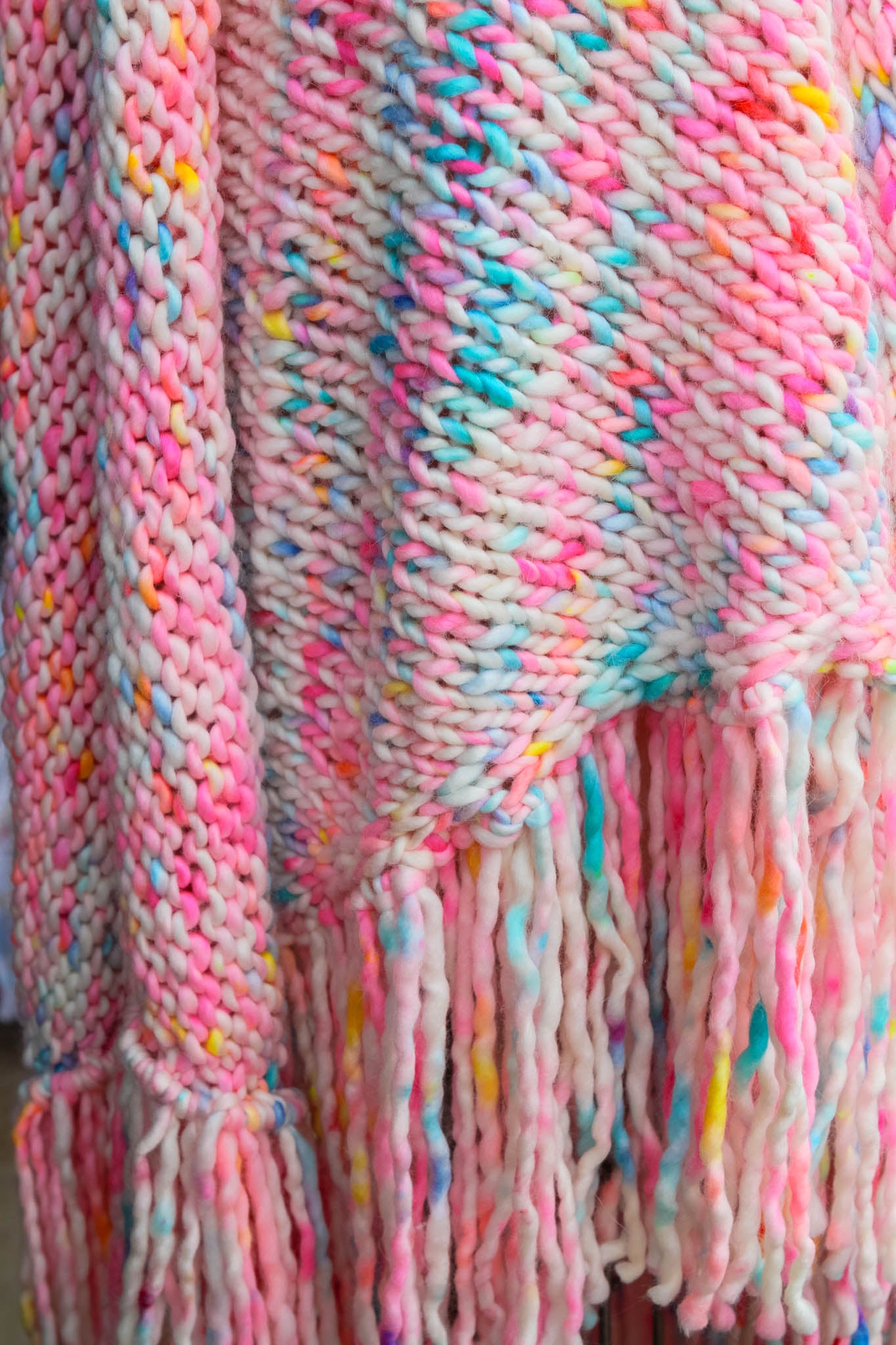 Close-up of a colorful knitted blanket/ shawl with fringes. chasing sunsets, hand dyed, sunset shawl, luxury fashion