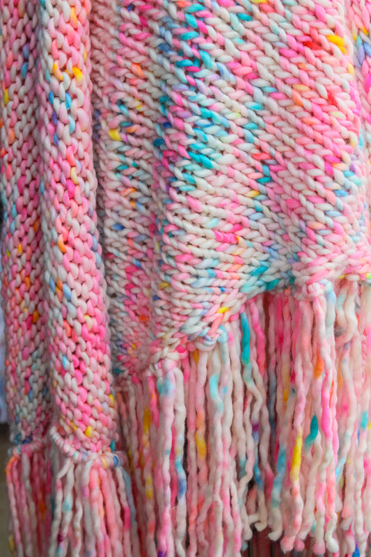 Close-up of a colorful knitted blanket/ shawl with fringes. chasing sunsets, hand dyed, sunset shawl, luxury fashion