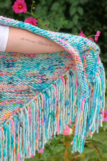 Neon Reef shawl draped with fringe flowing ocean-inspired tattoo visible, art meets fashion Luxury hand-dyed shawl with fringe detail — styled to reveal ocean-themed tattoo