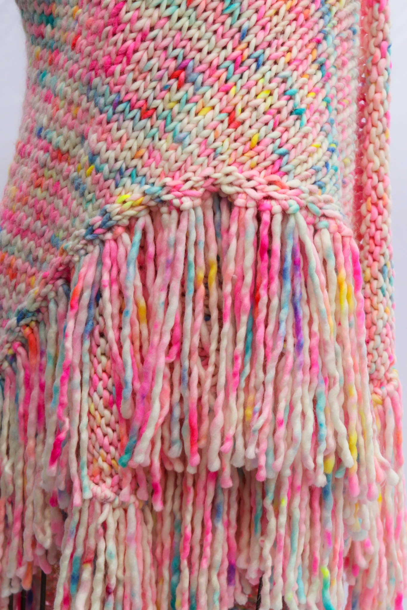 Multicolored knitted scarf with fringe on a white background