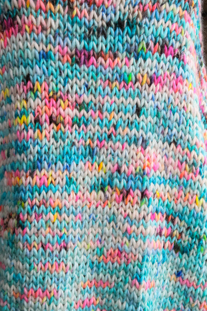 Close-up of Neon Reef shawl stitches turquoise, coral, and violet tones in hand-dyed luxury knitwear.	neon reef, colorway, knit texture, hand dyed, ocean inspired, luxury fashion